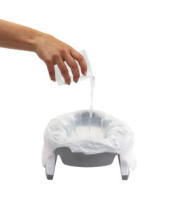 Ręka wlewa przezroczysty płyn do szarego nocnika wyłożonego białą plastikową torbą, demonstrując wygodę Wkłady jednorazowe do nocnika Potette, 30 szt. Proste białe tło skupia się na dłoni i nocniku.
